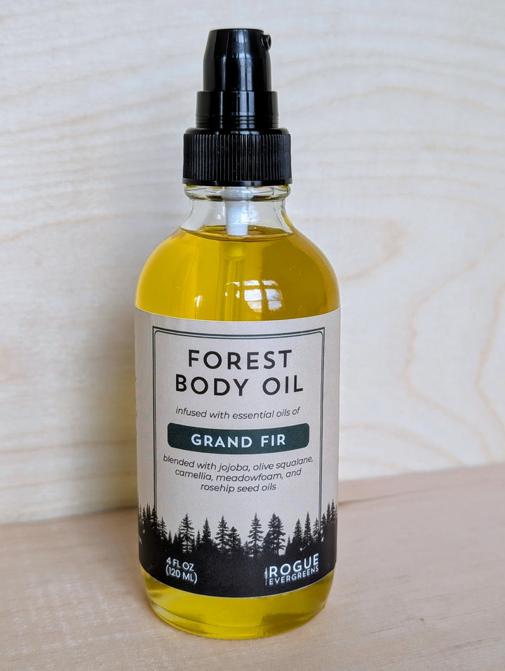 Bottle of Forest Body Oil with Grand Fir scent on a wooden surface