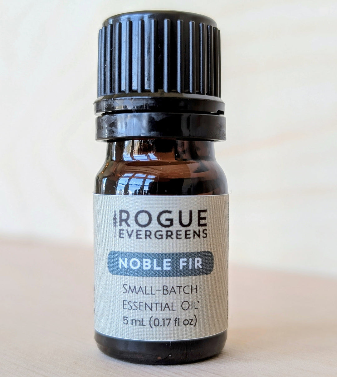 Bottle of Rogue Evergreens Noble Fir essential oil on a light background